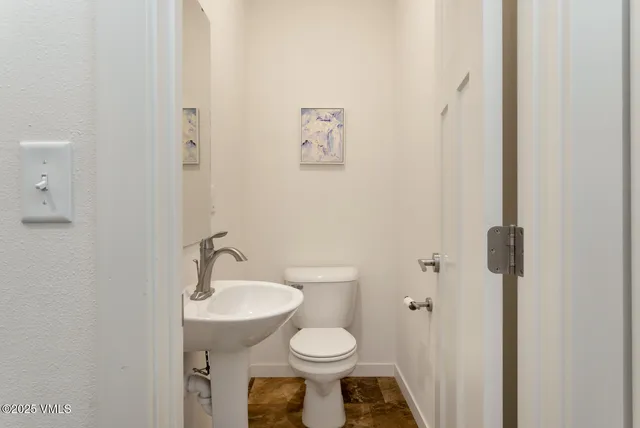 a bathroom with a toilet sink and a mirror
