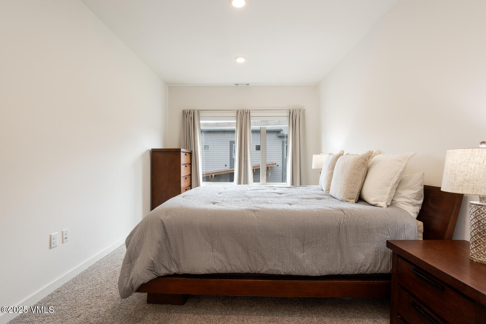 4 Uneva Court, Unit B1 Eagle, CO 81631 - Photo 17 of 44 a spacious bedroom with a bed and a lamp