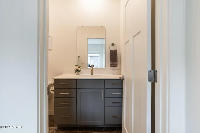 a bathroom with a sink vanity and a mirror
