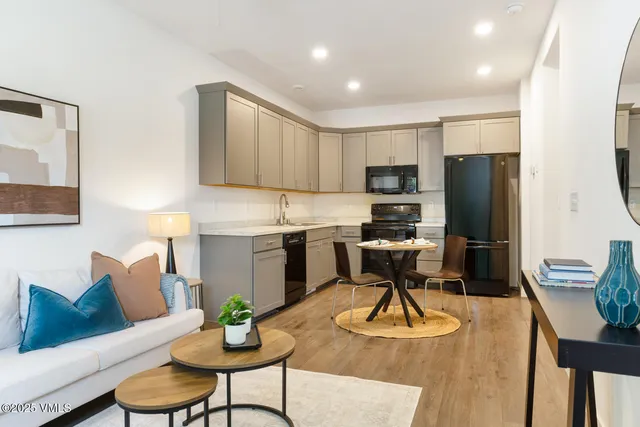 a living room with furniture and kitchen view
