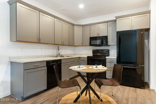 a kitchen with a refrigerator and a stove top oven