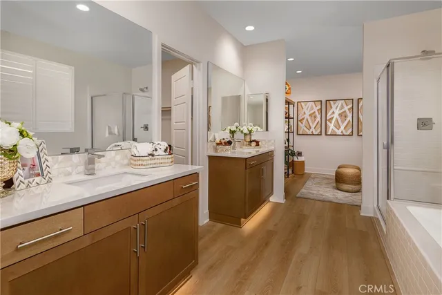 a spacious bathroom with a sink a mirror a bathtub and shower