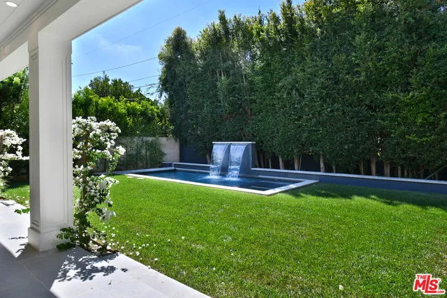 a kitchen with stainless steel appliances kitchen island granite countertop a dining table chairs and view living room