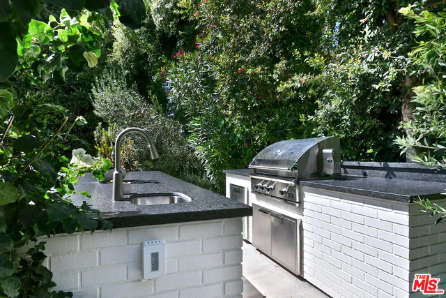 a kitchen with stainless steel appliances a table chairs sink and stove top oven