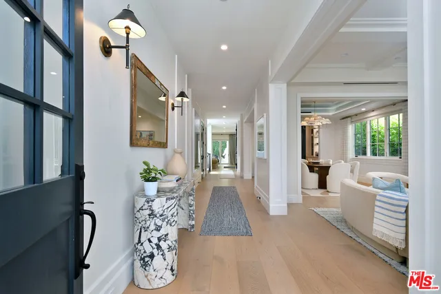 a view of a hallway with furniture and a chandelier