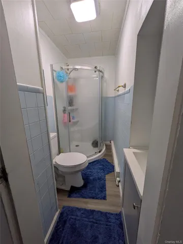 a bathroom with a granite countertop shower and a toilet