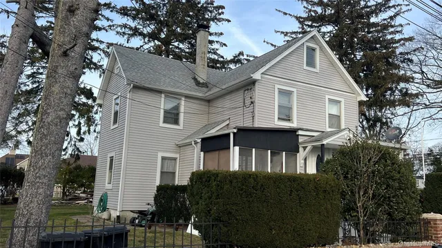 a front view of a house with a tree