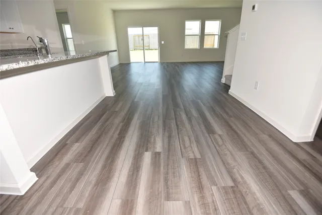 a view of a kitchen from the hallway with wooden floor