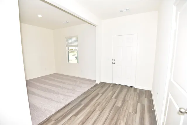 a view of a room with wooden floor and white walls