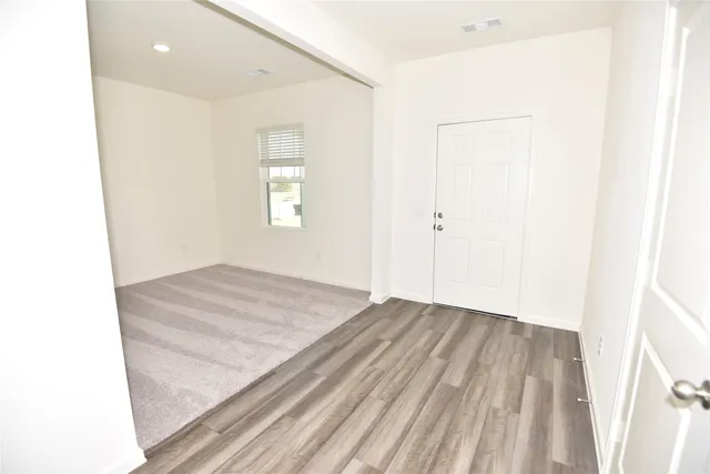 a view of a room with wooden floor and window