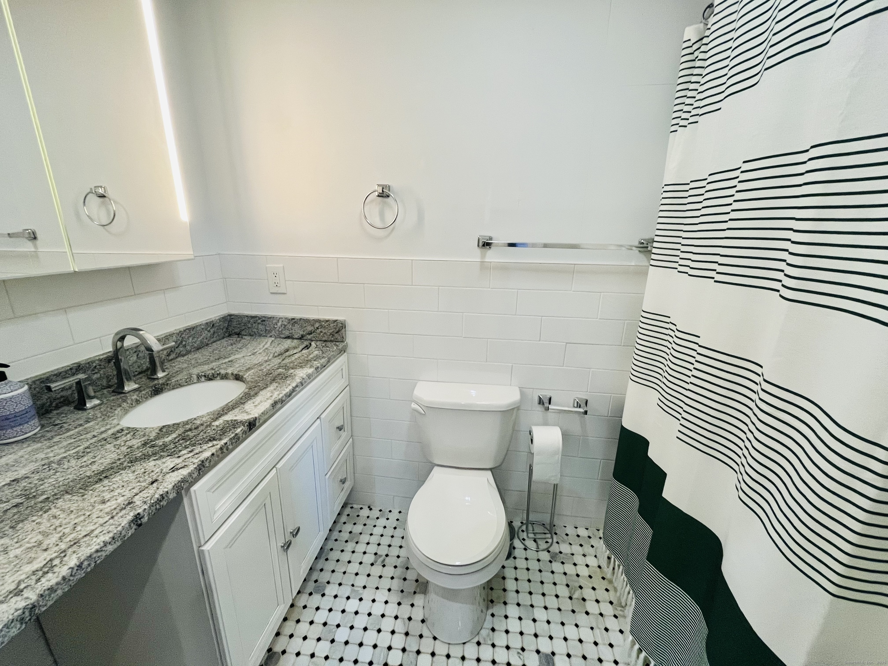597 Chapel Street, Unit 2FR New Haven, CT 06511 - Photo 13 of 15 a bathroom with a granite countertop toilet sink and mirror