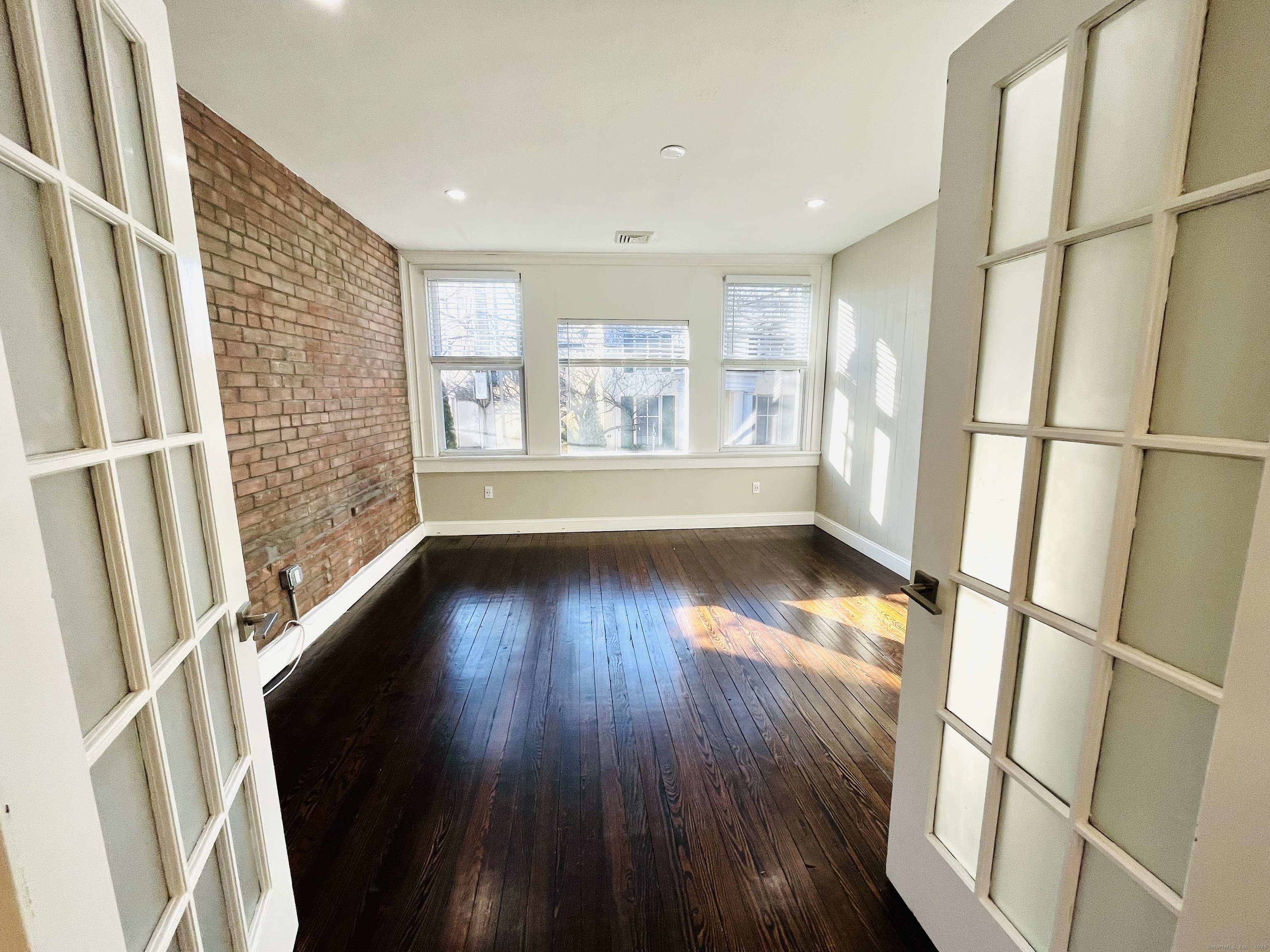 597 Chapel Street, Unit 2FR New Haven, CT 06511 - Photo 2 of 15 a view of an empty room with wooden floor and a window