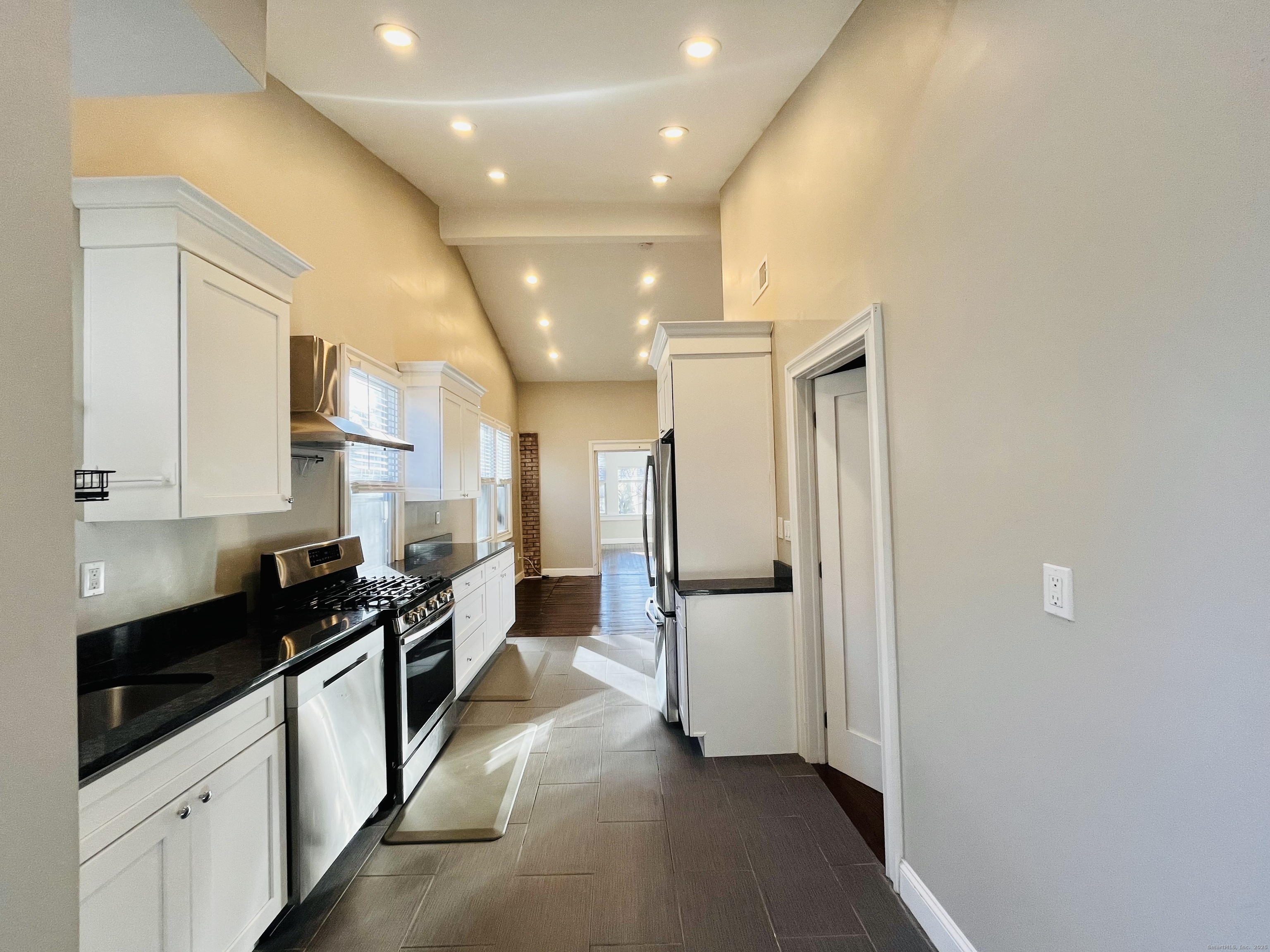 597 Chapel Street, Unit 2FR New Haven, CT 06511 - Photo 7 of 15 a kitchen with stainless steel appliances a refrigerator a sink and white cabinets