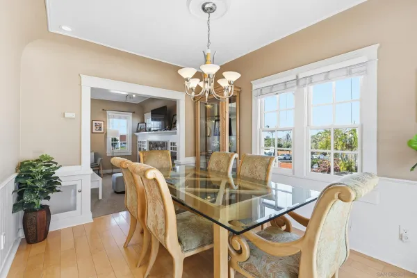 a dining room with furniture potted plants and wooden floor