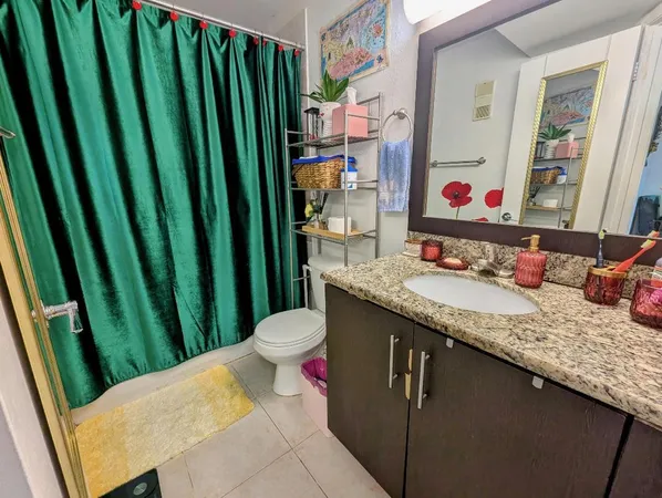 a bathroom with a granite countertop sink and a large mirror