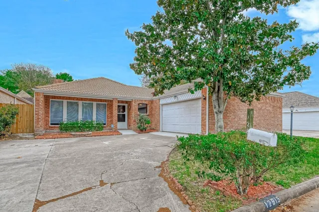 a front view of a house with a garden and trees