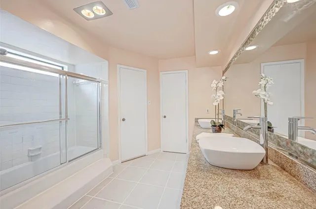 a bathroom with a tub a sink and a mirror