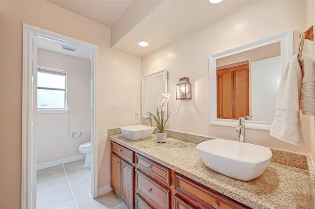a bathroom with a granite countertop sink a toilet and a mirror