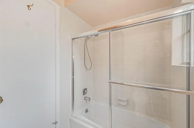 a bathroom with a shower and a glass door