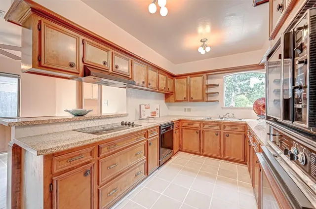 a kitchen with stainless steel appliances granite countertop a sink and dishwasher a stove with wooden cabinets