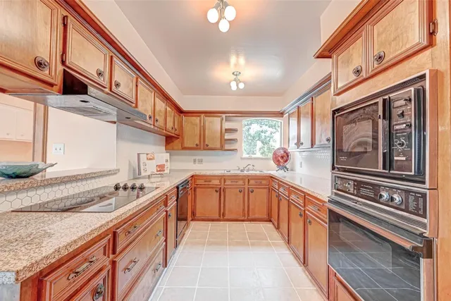 a kitchen with stainless steel appliances granite countertop a sink and cabinets