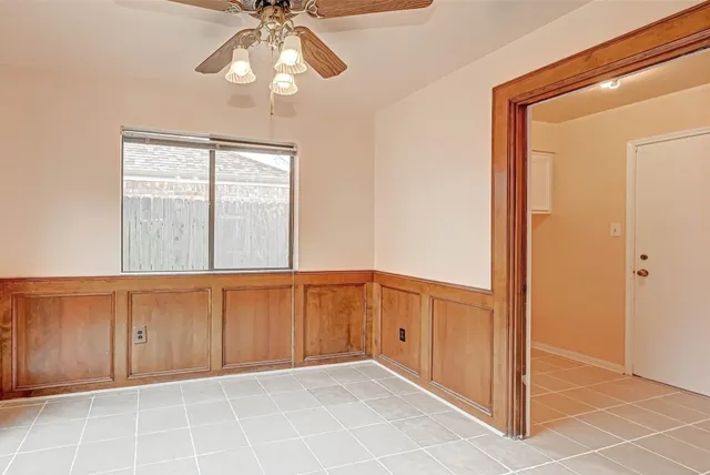 a view of an empty room and chandelier fan