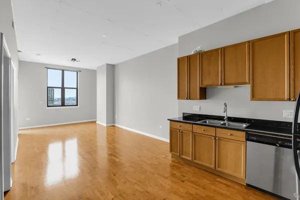 a kitchen with granite countertop wooden cabinets stainless steel appliances a sink and a window
