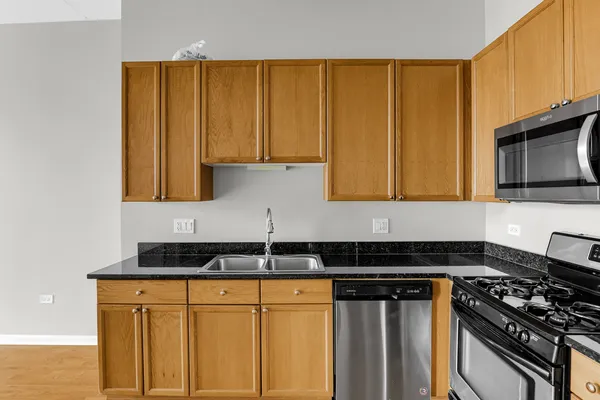 a kitchen with granite countertop cabinets and black appliances