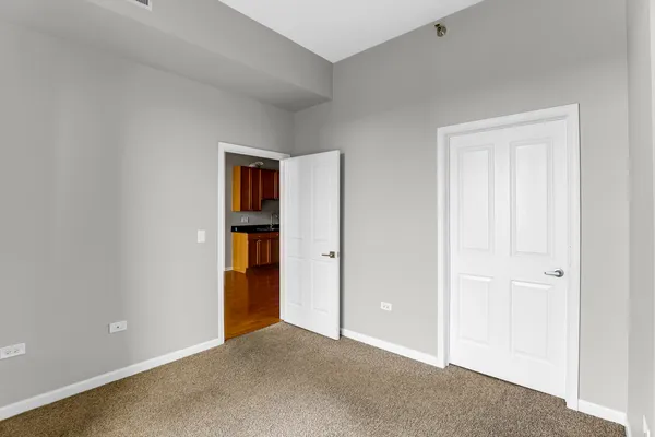 a view of an empty room with closet and wooden floor