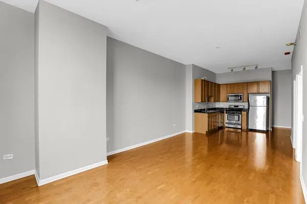 a view of an empty room with kitchen