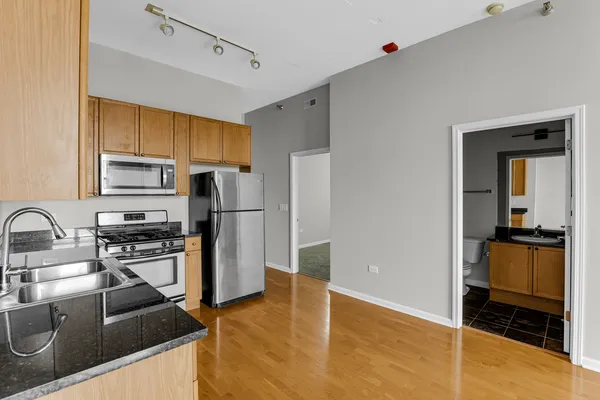 a kitchen with stainless steel appliances granite countertop a refrigerator stove and sink