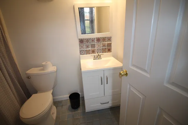 a bathroom with a toilet a sink and a window