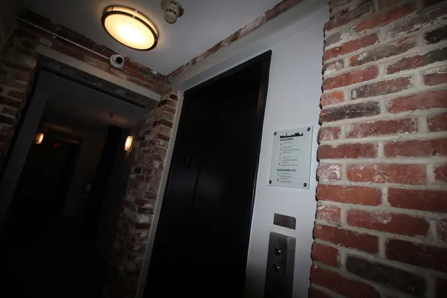 a view of a kitchen with a refrigerator a white wall