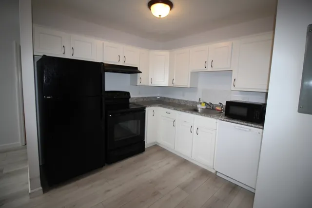 a kitchen with cabinets and black appliances