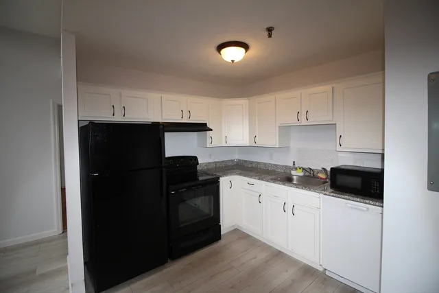 a kitchen with a sink a refrigerator and cabinets
