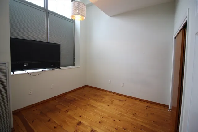 a room with wooden floor and mirror