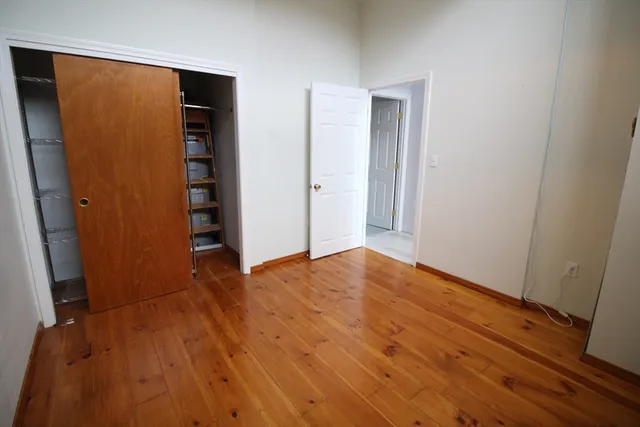 an empty room with wooden floor and closet