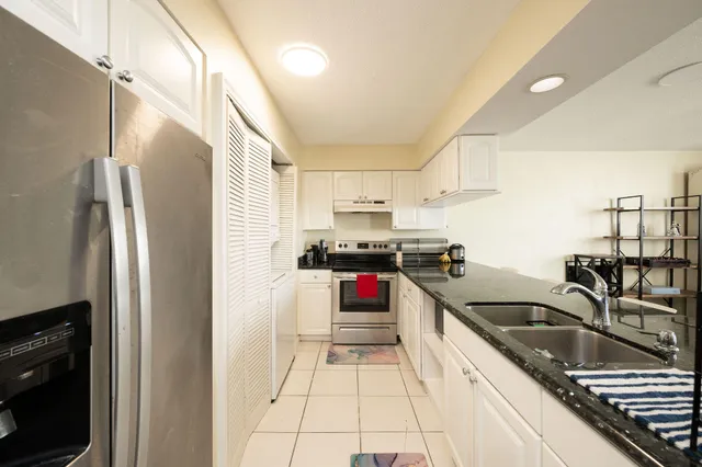 a kitchen with granite countertop a refrigerator and a sink