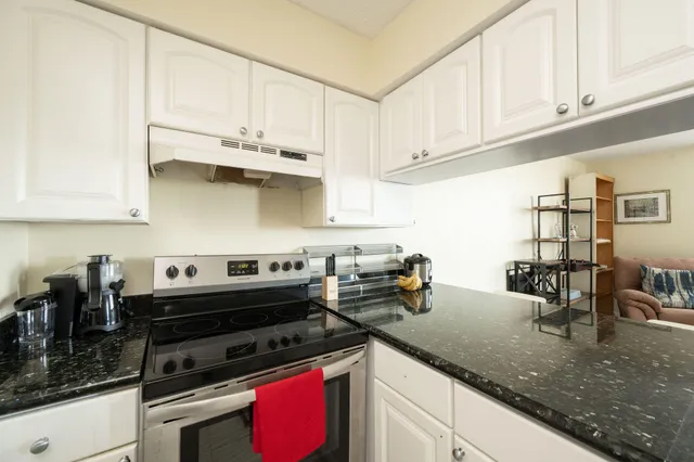a kitchen with stainless steel appliances granite countertop a sink stove and cabinets