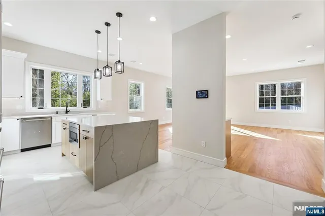 a large kitchen with kitchen island a sink a stove and a refrigerator
