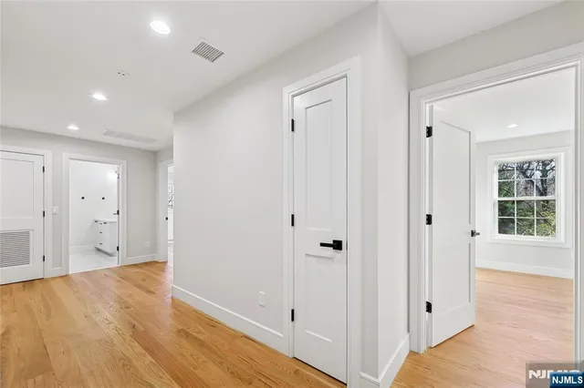a view of a hallway with wooden floor and windows