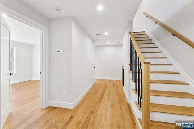 a view of a hallway with wooden floor and staircase