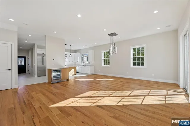 a view of a kitchen with kitchen island a sink wooden floor and a refrigerator