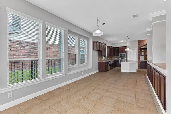 a large white kitchen with a large window and stainless steel appliances