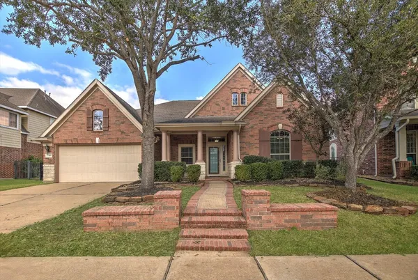 a front view of a house with a yard and potted plants