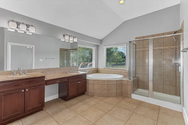 a spacious bathroom with a granite countertop tub sink and mirror