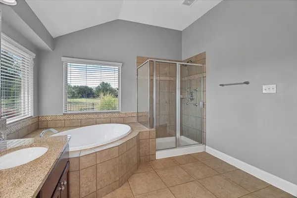a bathroom with a granite countertop tub sink and shower