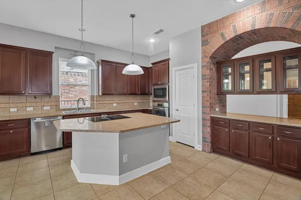 a kitchen with granite countertop a sink and a stove