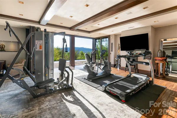 a living room with furniture flat screen tv and a large window