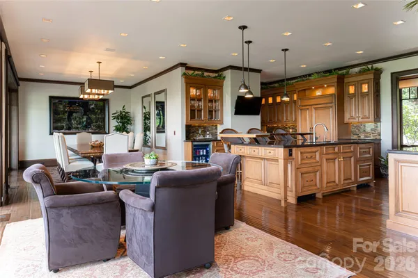 a living room with furniture kitchen area and a wooden floor